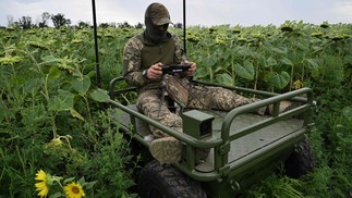 Com a ajuda de um robô teleguiado, um militar ucraniano resgata um de seus companheiros feridos e tenta levá-lo a um local seguro, longe da linha de frente — Foto: Genya Savilov/AFP