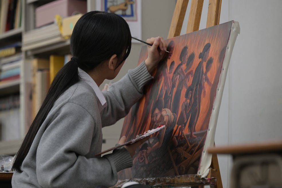 Estudante da escola Motomachi, em Hiroshima, faz quadro inspirado em relatos dos sobreviventes na bomba atômica de 1945 — Foto: RICHARD A. BROOKS / AFP