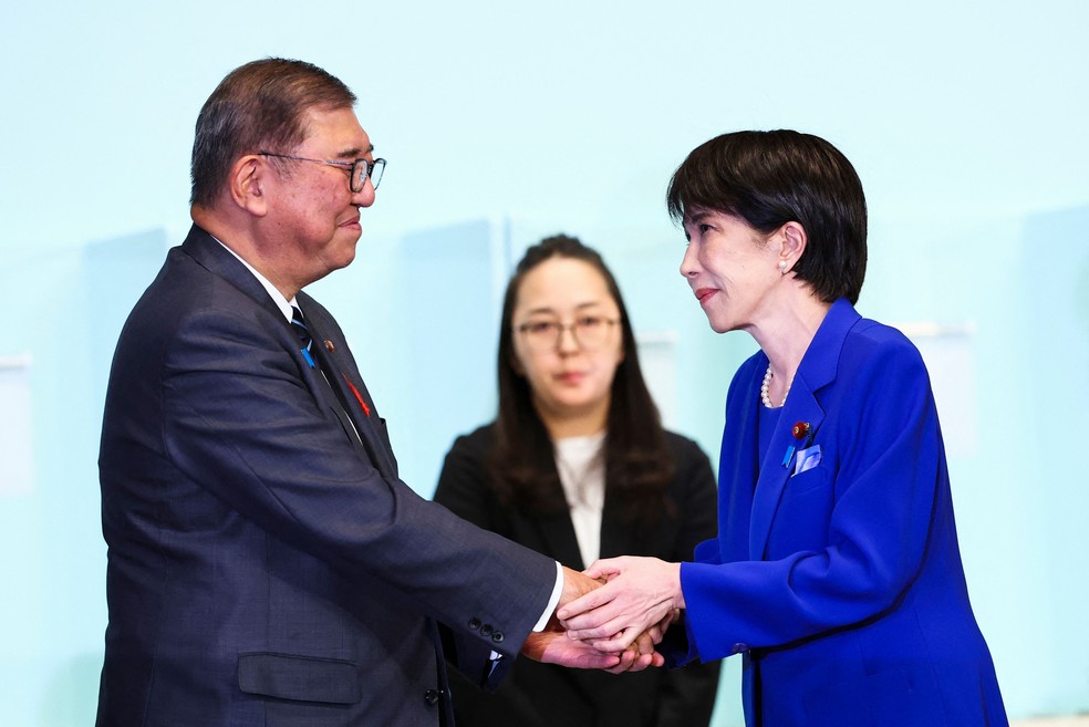 Takaichi cumprimenta Shigeru Ishiba após ser escolhida para sucedê-lo como líder do PDL — Foto: Kim Kyung-Hoon/AFP