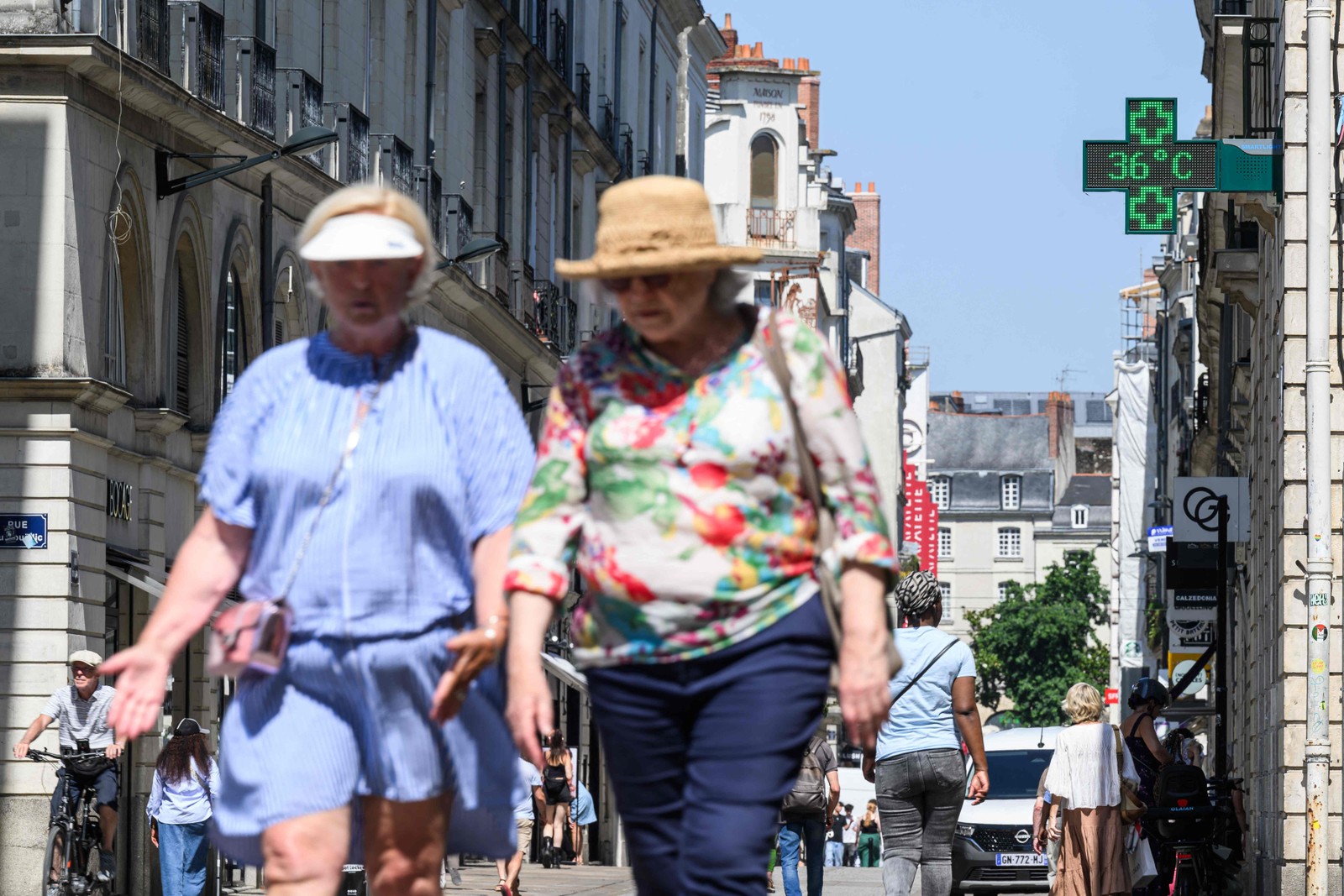 PESSOAS CAMINHAM PELA RUA ENQUANTO umtermômetrroindica depatura de36ºC Durante de Calor