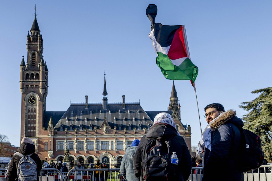 Ativista ergue bandeira palestina em frente à Corte Internacional de Justiça (CIJ)
