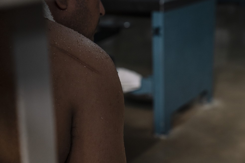 Prisioneiro tenta se refrescar com toalha molhada no pescoço no Texas. — Foto: Verónica G. Cárdenas/The New York Times