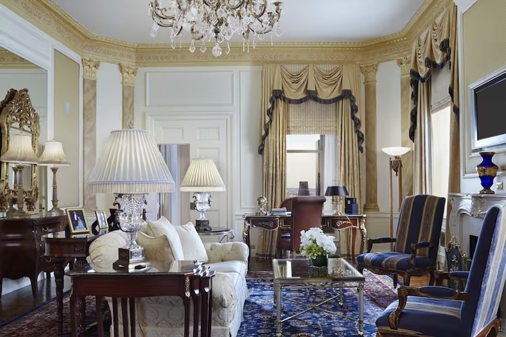 A sala combina móveis antigos restaurados com tapetes elegantes. — Foto: www.waldorfnewyork.com
