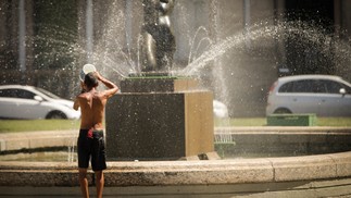 Homem usa água do chafariz para se refrescar, no centro do Rio de Janeiro — Foto: Roberto Moreyra/Agência O Globo