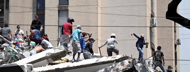 Equipes de resgate procuram por sobreviventes entre os escombros de um prédio que desabou após um terremoto em Cali, Colômbia, — Foto: Joaquin Sarmiento / AFP