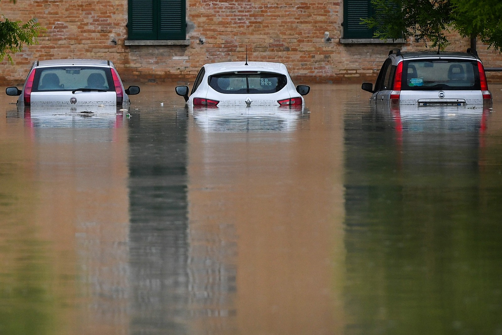 Carros inundados são fotografados em uma rua de Cesena — Foto: Alessandro SERRANO / AFP