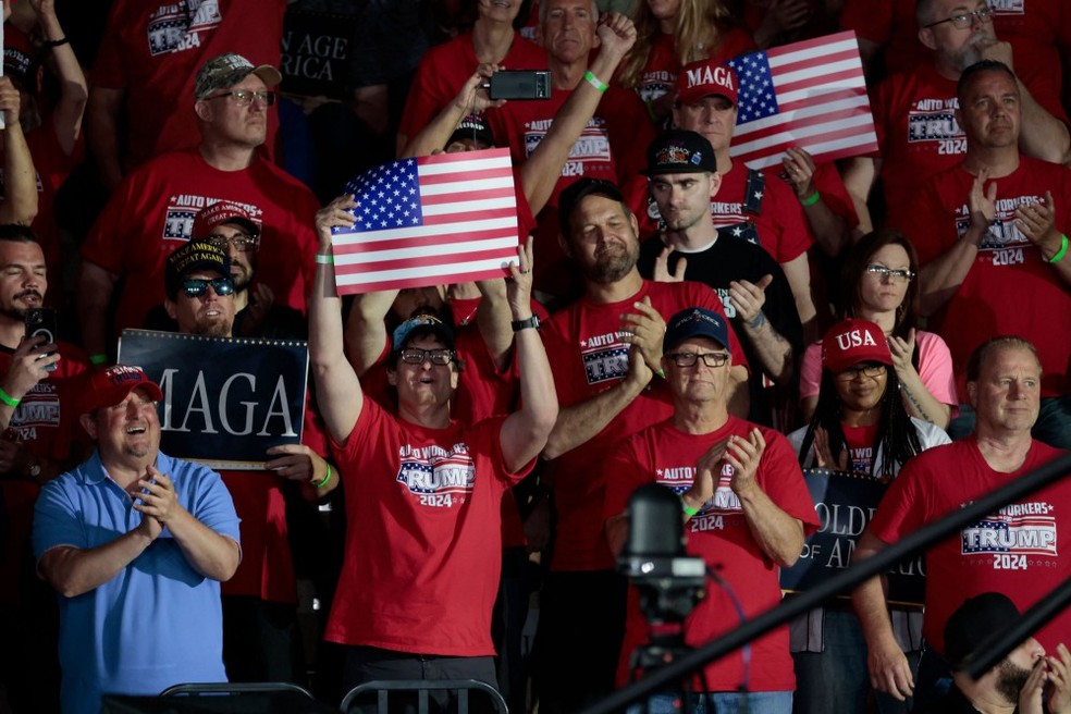 Trabalhadores da indústria automobilística aplaudem Trump antes de um evento com o presidente dos EUA, Donald Trump, para marcar seus primeiros 100 dias no cargo, no Macomb Community College, em 29 de abril de 2025, em Warren, Michigan — Foto: JEFF KOWALSKY / AFP