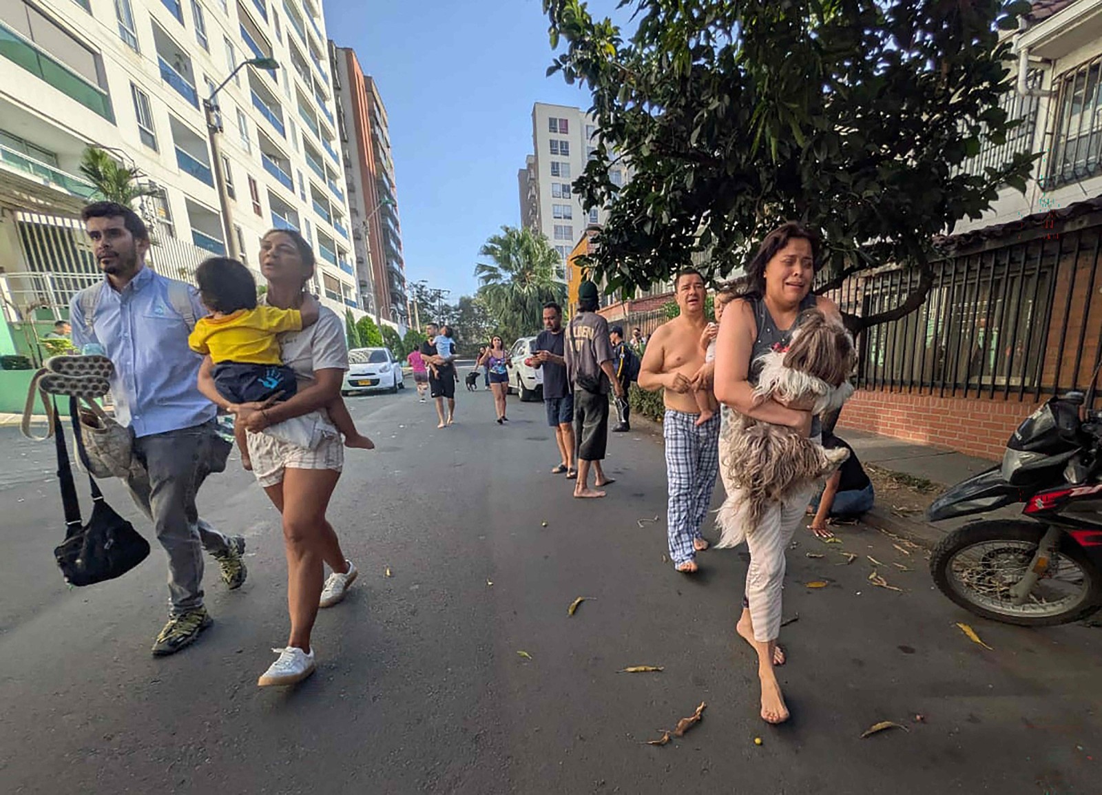 Pessoas caminham por uma rua após evacuarem suas casas devido a um terremoto em Cali, Colômbia. — Foto: Joaquín SARMIENTO / AFP
