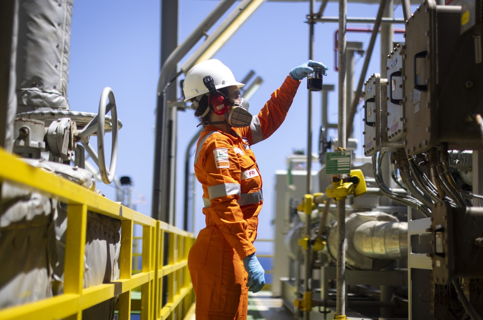 A técnica de operações Josy Araújo coleta e examina uma amostra de petróleo — Foto: Márcia Foletto / Agência O Globo