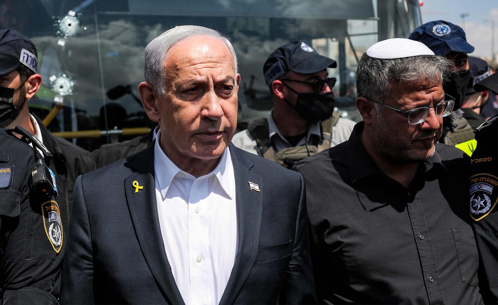 O primeiro-ministro israelense, Benjamin Netanyahu, e o ministro da Segurança Nacional Itamar Ben-Gvir visitam o local de um tiroteio no cruzamento da estrada Ramot, em Jerusalém Oriental, em setembro — Foto: Ronen Zvulun/AFP