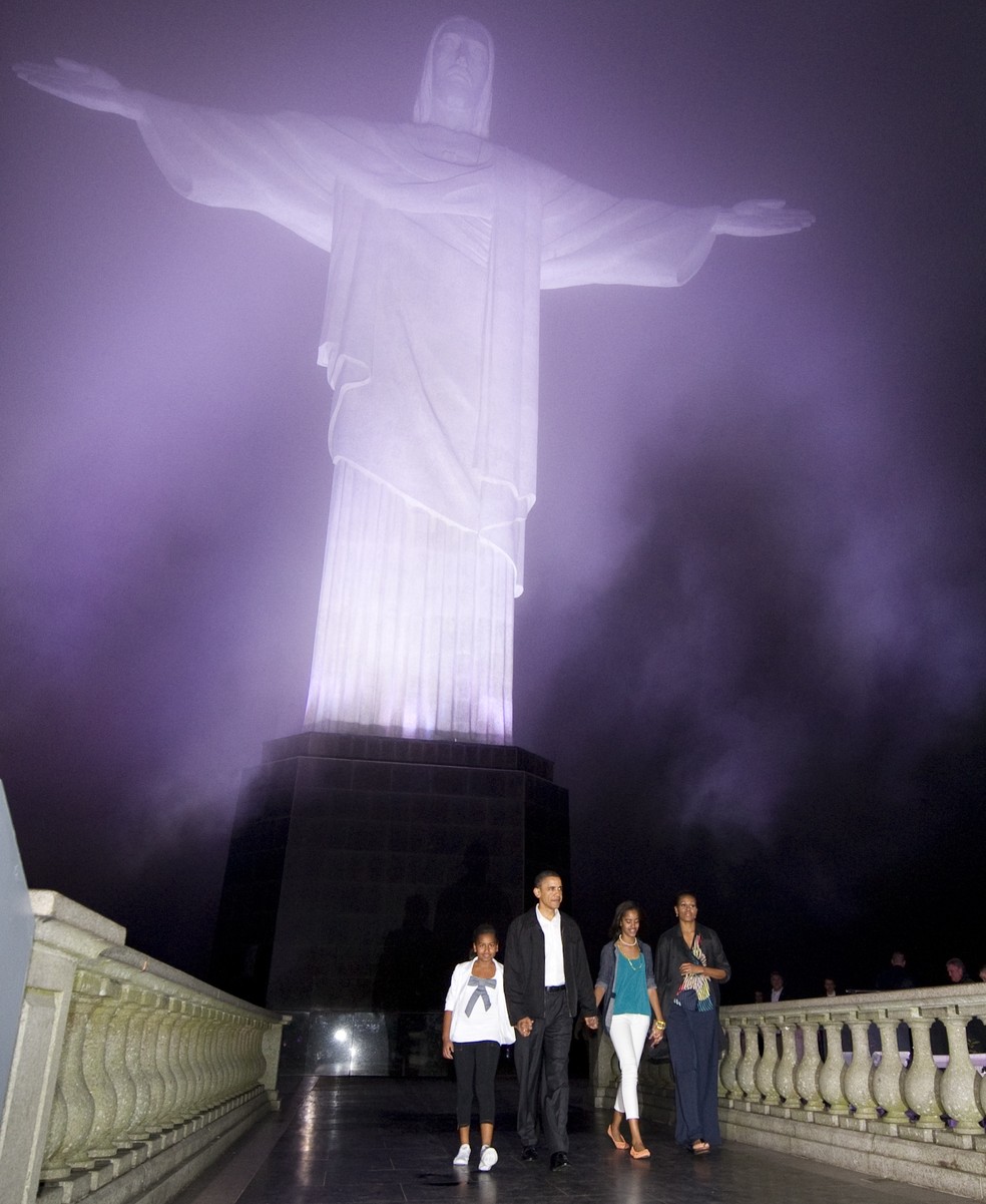 Barack Obama ao lado de Michelle e das filhas, Sasha e Malia, em visita sem chuva ao Cristo Redentor — Foto: Saul Loeb / AFP / 20-03-2011