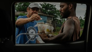 Anton Cornel, à esquerda, explica os passos para uma coleta noturna de mosquitos para um coletor voluntário na vila de São Joaquim — Foto: Natalija Gormalova / The New York Times