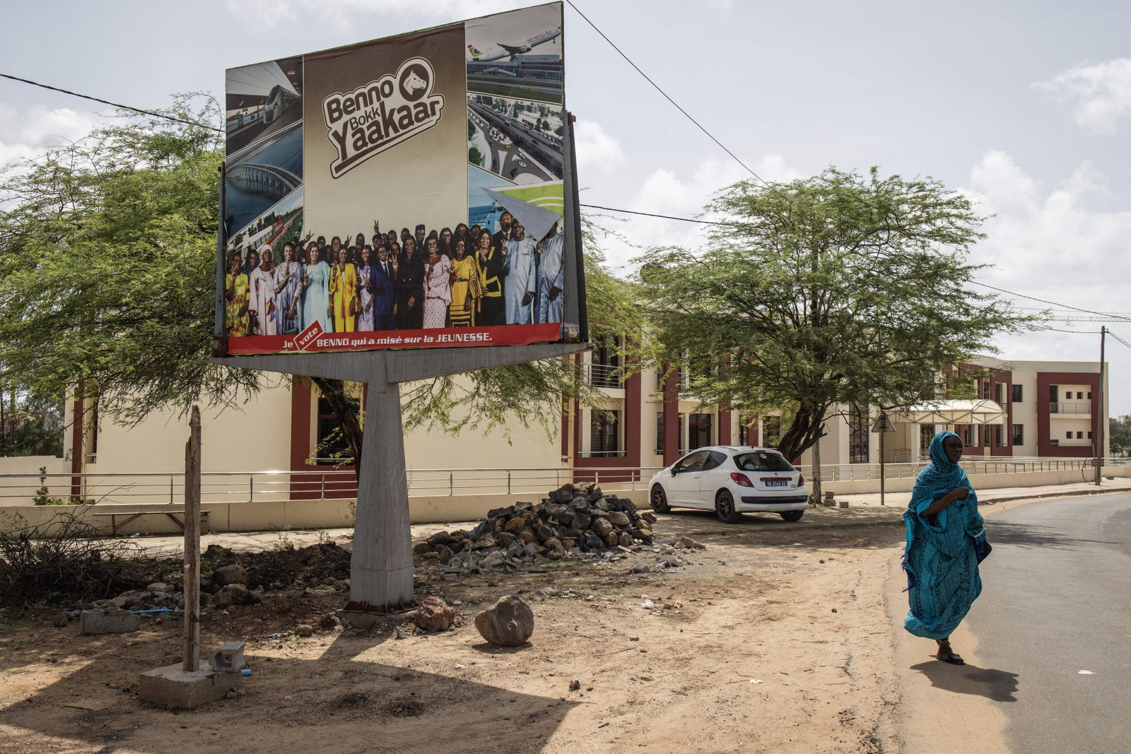 Mulher passa por cartaz eleitoral em Dakar. O Senegal elege no próximo domingo (31) os 165 membros da Congresso Nacional — Foto: JOHN WESSELS / AFP