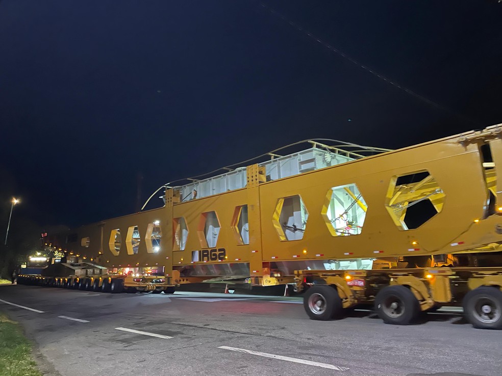 Comboio da carreta gigante possui três caminhões que vão na frente, puxando, e dois atrás, segurando — Foto: Madson Gama