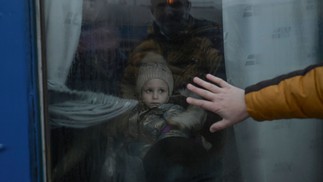 Um pai se despede da sua filha pela janela do trem durante evacuação na estação central de Odessa, na Ucrânia, em 7 de março. — Foto: BULENT KILIC/AFP/07-03-2022