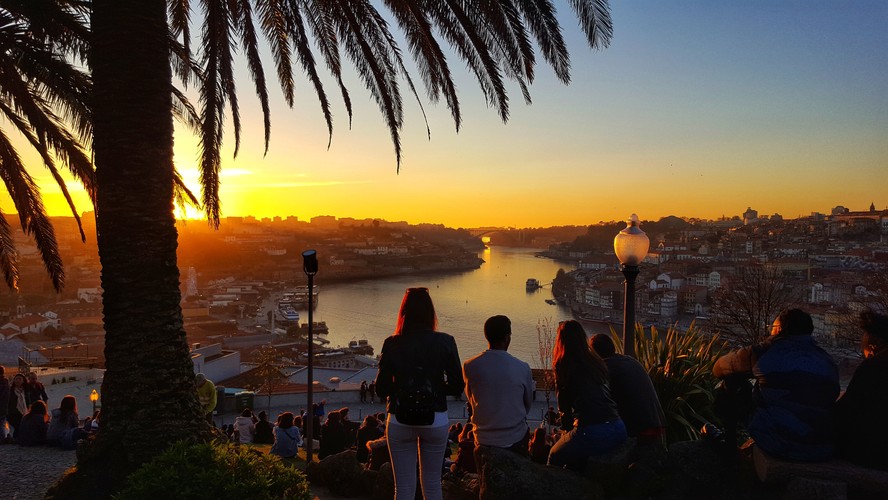 Pessoas assistem ao pôr do sol no Rio Douro a partir do Jardim do Morro, em Gaia