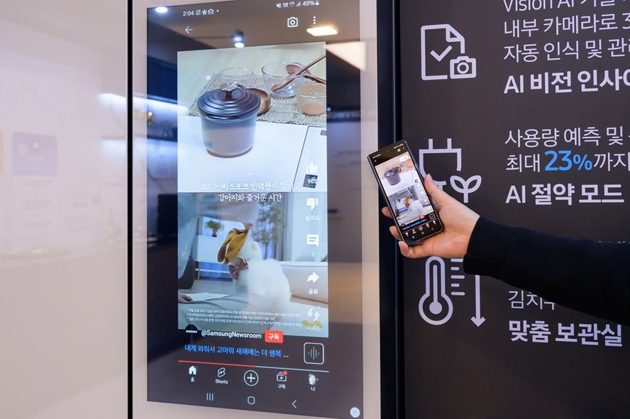 Pessoa apontando o celular para o painel digital de uma máquina de lavar que exibe um código de erro, usando IA para traduzir o problema.