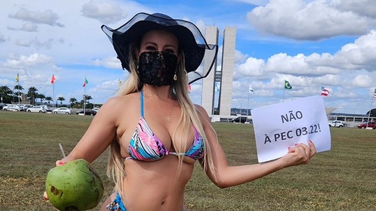 Ex-candidata funkeira MC Bandida protesta contra PEC das Praias com biquíni e água de coco em frente ao Congresso
