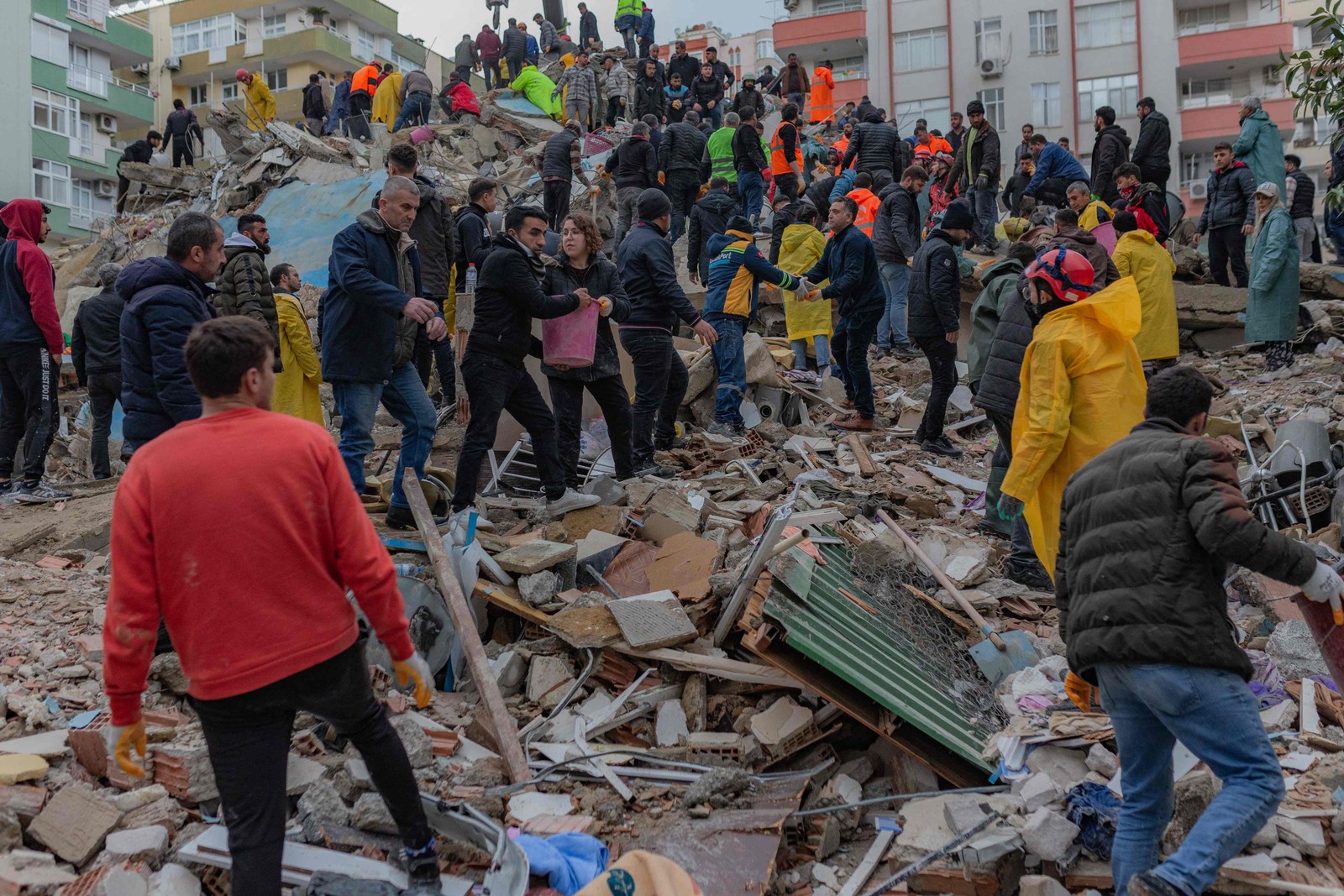 Equipes de resgate procuram sobreviventes entre os escombros de prédios desabados em Adana, em 6 de fevereiro de 2023, depois que um terremoto de magnitude 7,8 atingiu o sudeste da Turquia — Foto: Can Erok / AFP