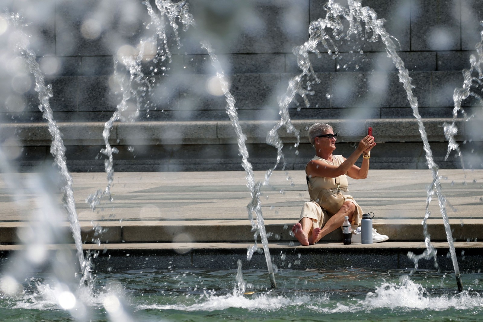 Mulher se refresca na fonte do Memorial da Segunda Guerra Mundial, em 28 de julho de 2023, em Washington — Foto: ALEX WONG / Getty Images via AFP
