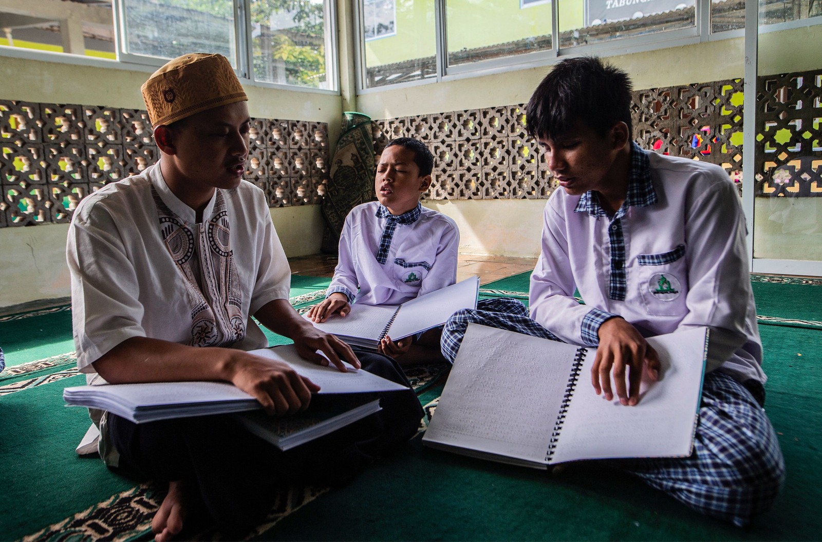 Estudantes muçulmanos com deficiência visual leem cópias do Alcorão em braille em um internato em Bogor, na Indonésia — Foto: ADITYA AJI / AFP