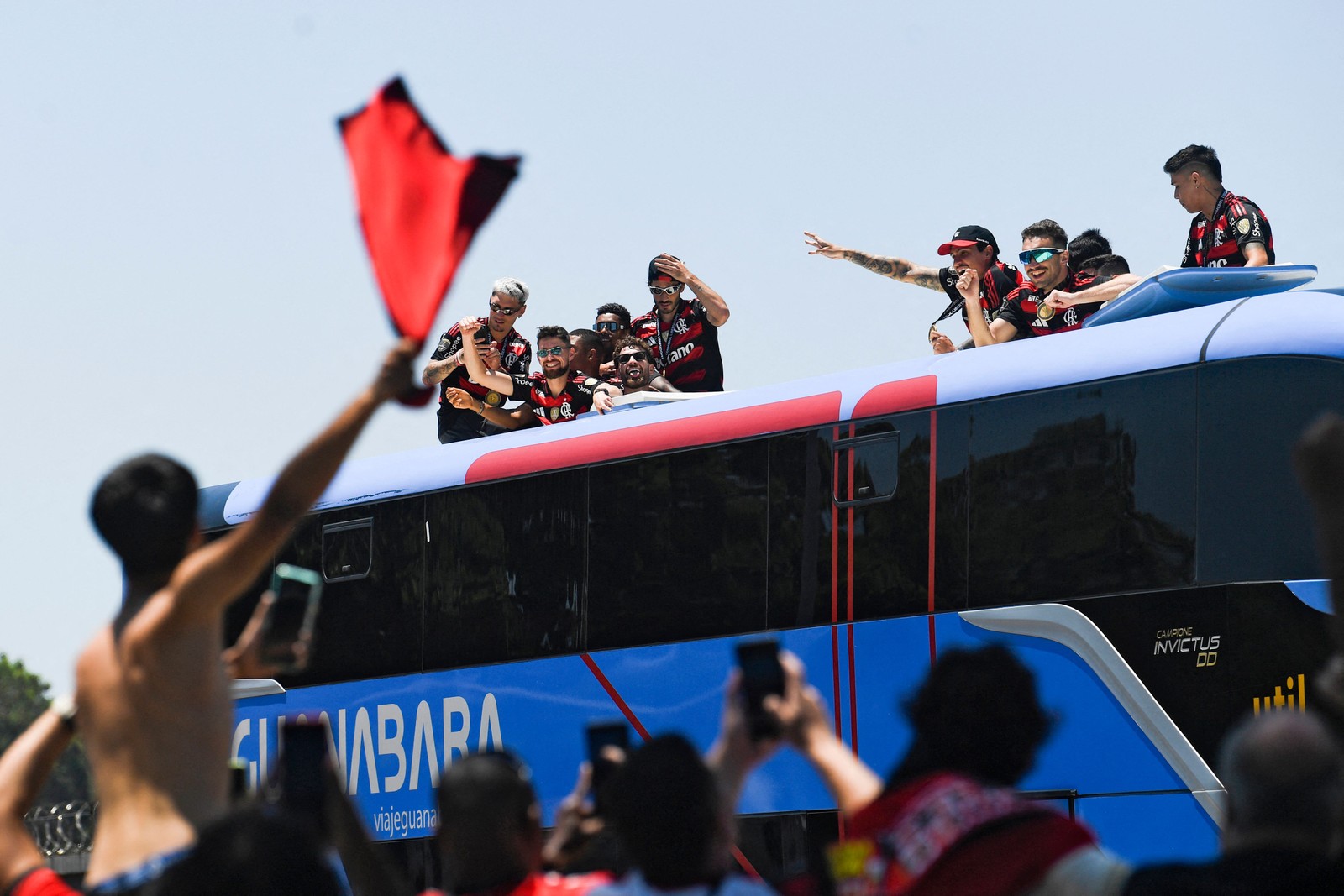 Brazil's Flamengo players celebrate as they leave on a bus the Galeao airport in Rio de Janeiro, Brazil, on November 30, 2025, a day after clinching the 2025 Copa Libertadores title — Foto: (Photo by Daniel RAMALHO / AFP)