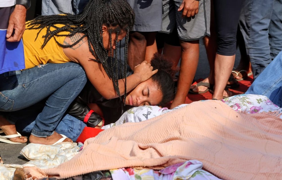 Mulheres lamentam junto aos corpos enfileirados na Penha — Foto: Fabiano Rocha / Agência O Globo