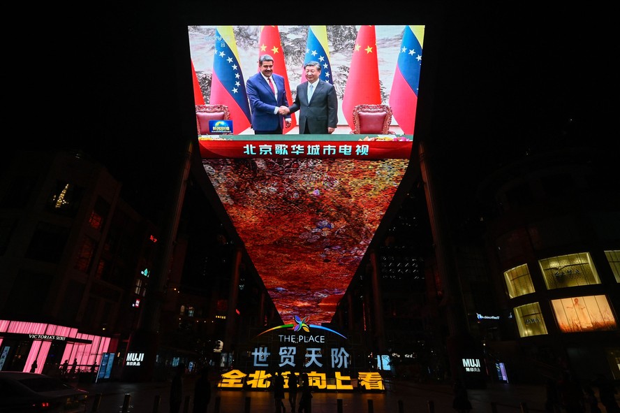 Encontro entre Xi e Maduro é exibido em telão gigante fora de shopping em Pequim.