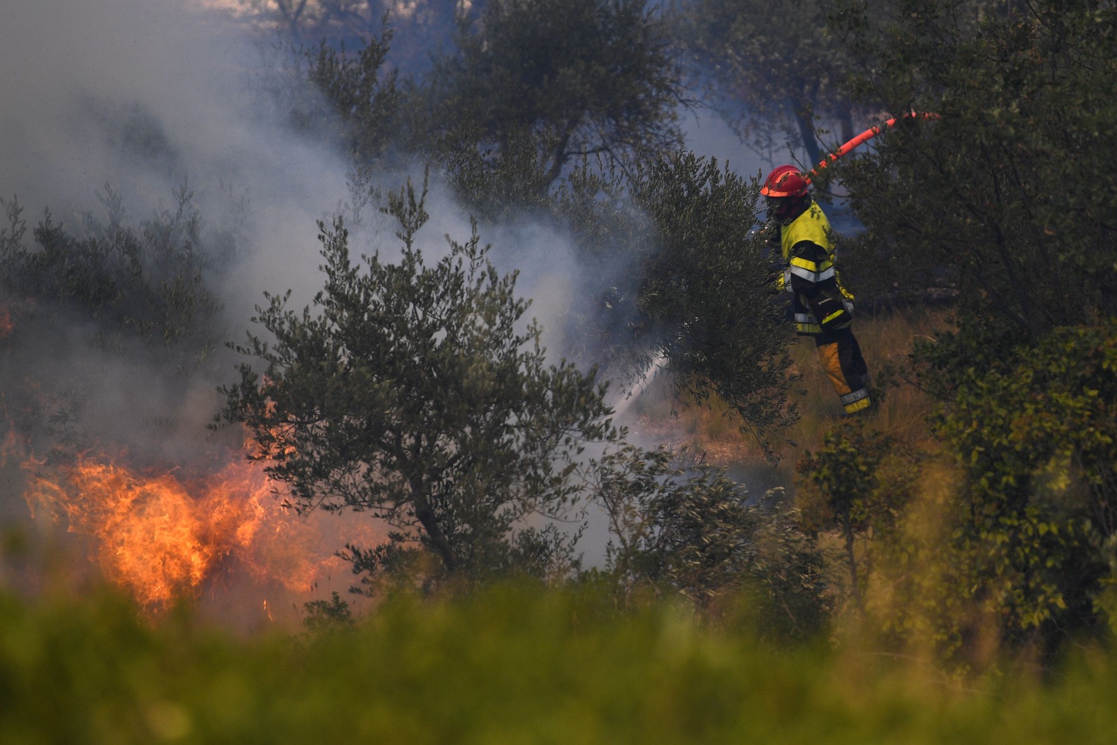 Bombeiros trabalham para apagar um incêndio florestal em Tarascon, sudeste da França  — Foto: CLEMENT MAHOUDEAU / AFP