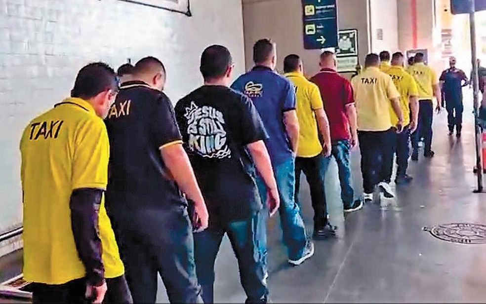 Operação no aeroporto. Agentes da Polícia Civil conduzem 18 “jóqueis” para depor: encarregados de abordar turistas no saguão e levá-los aos táxis irregulares — Foto: Reprodução