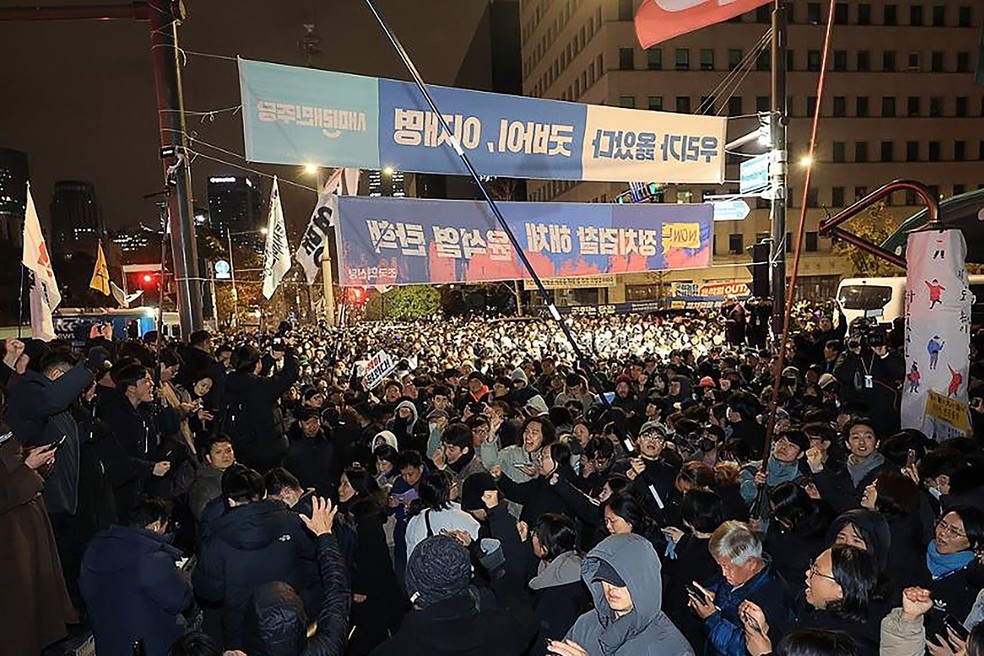 Manifestantes protestam em frente ao Parlamento da Coreia do Sul após decreto da lei marcial — Foto: AFP