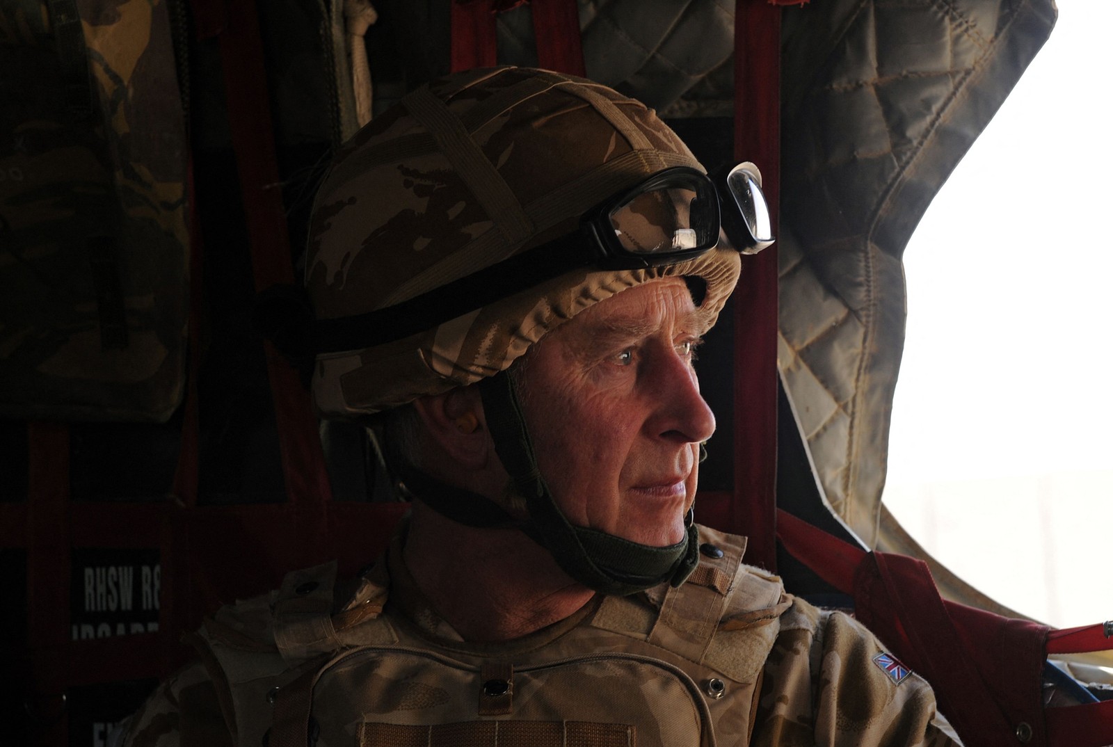 O príncipe Charles olha pela janela de um helicóptero militar britânico a caminho de Lashkar Gah, em 25 de março de 2010  — Foto: MASSOUD HOSSAINI / AFP