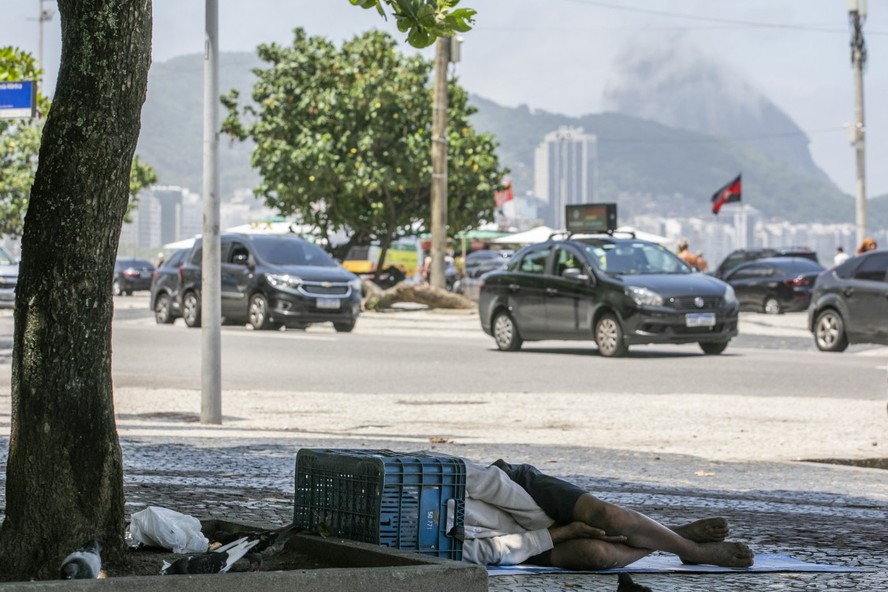 Pessoa em situação de rua dorme na calçada em Copacabana