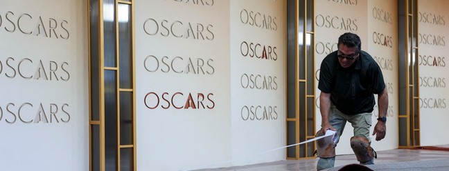 Funcionário coloca o tapete vermelho na área de entrada onde a 98ª cerimônia do Oscar acontece — Foto: ANGELA WEISS / AFP