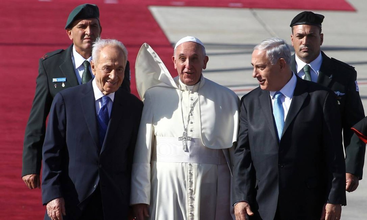 O Papa Francisco caminha ao lado do presidente israelense, Shimon Peres (esquerda), e do primeiro-ministro israelense, Benjamin Netanyahu, durante uma cerimônia de boas-vindas ao chegar ao aeroporto Ben Gurion, em maio de 2014, perto de Tel Aviv  — Foto: DAVID BUIMOVITCH / AFP