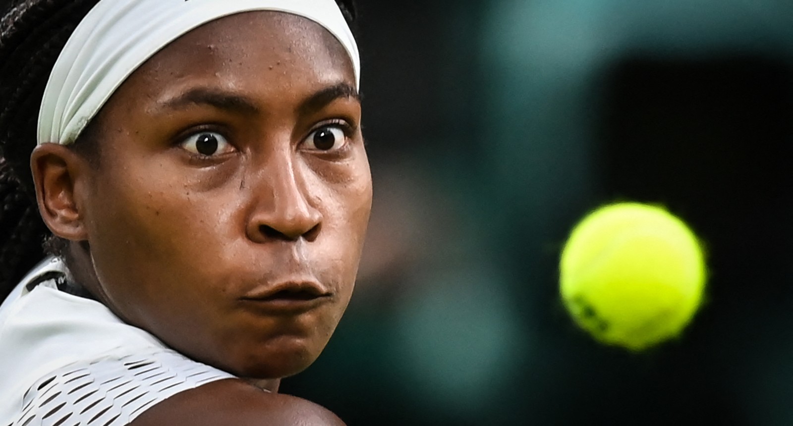 A estadunidense Coco Gauff foca o olhar na bola antes da devolução para a romena Mihaela Buzarnescu durante a partida de tênis individual feminino no quarto dia do Campeonato de Wimbledon — Foto: GLYN KIRK / AFP