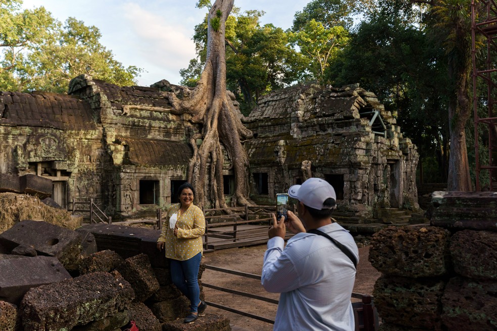 Casal em visita ao complexo de Angkor Wat, considerada a maior estrutura religiosa do mundo — Foto: Thomas Cristofoletti/The New York Times