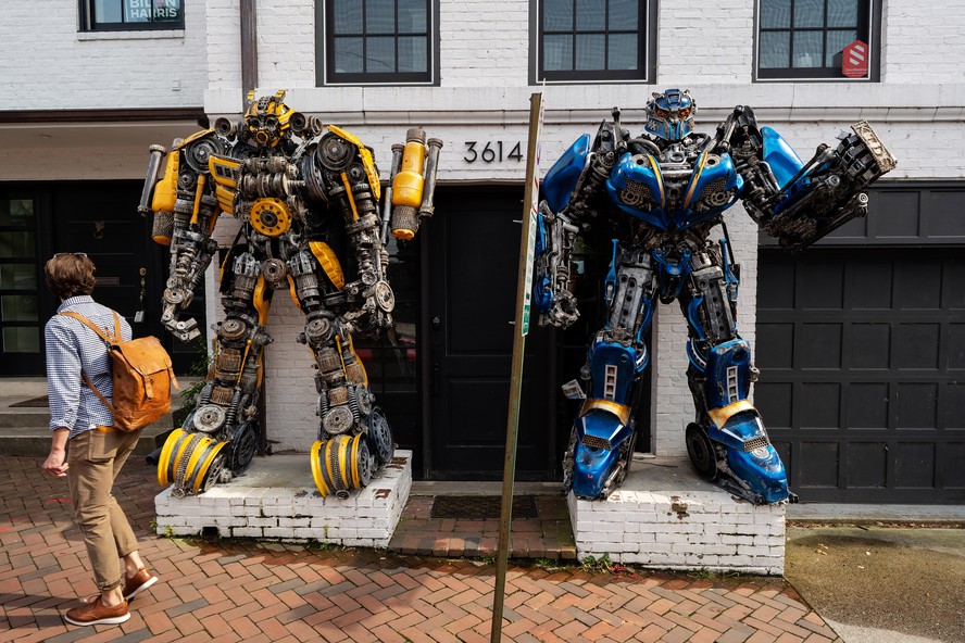 Bumblebee, à esquerda, e Optimus Prime estão do lado de fora de uma casa no bairro de Georgetown, em Washington