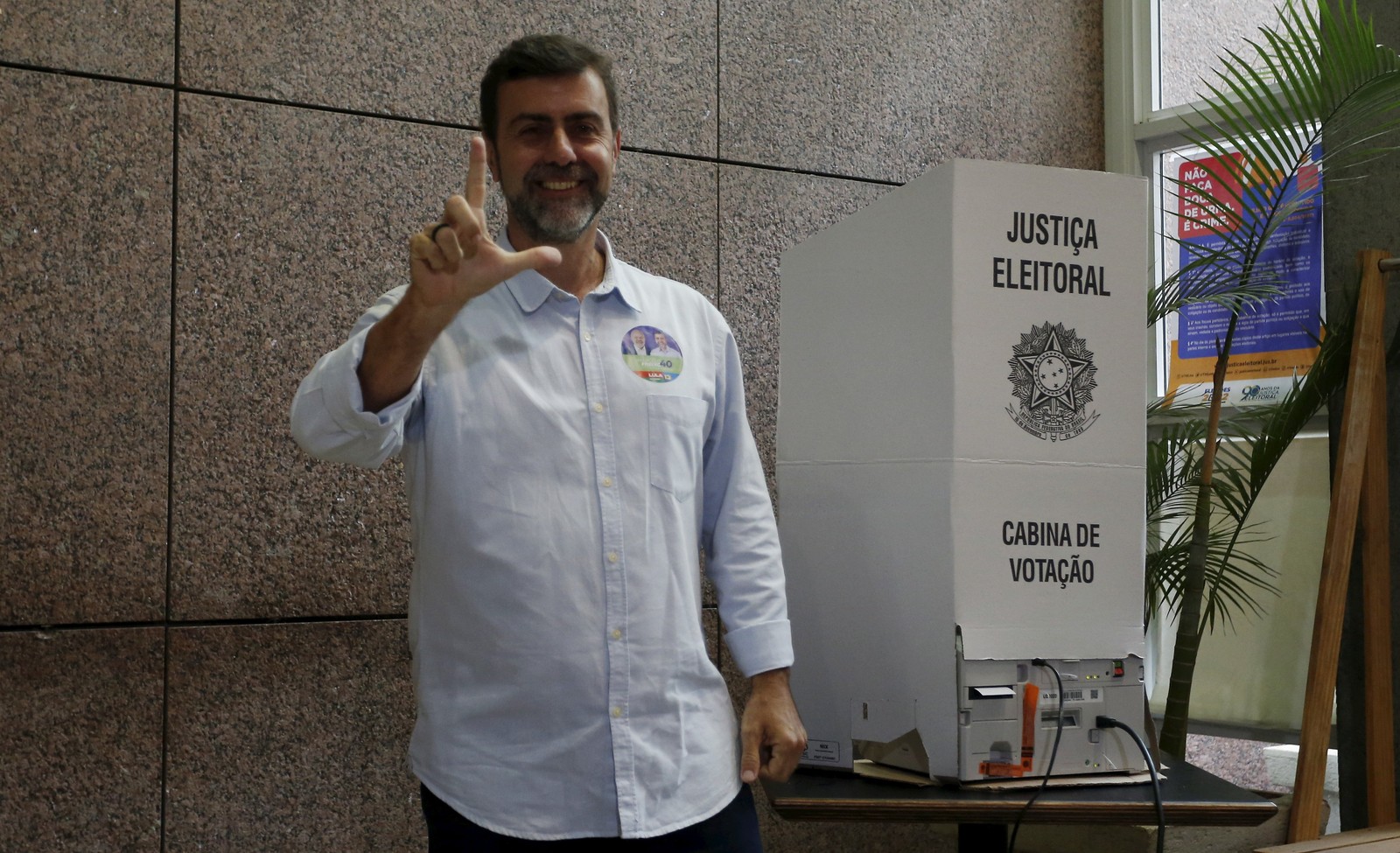 O candidato do PSB ao governo do Rio, Marcelo Freixo, fez o L de Lula com os dedos ao votar na Zona Sul do Rio  — Foto: Fabiano Rocha