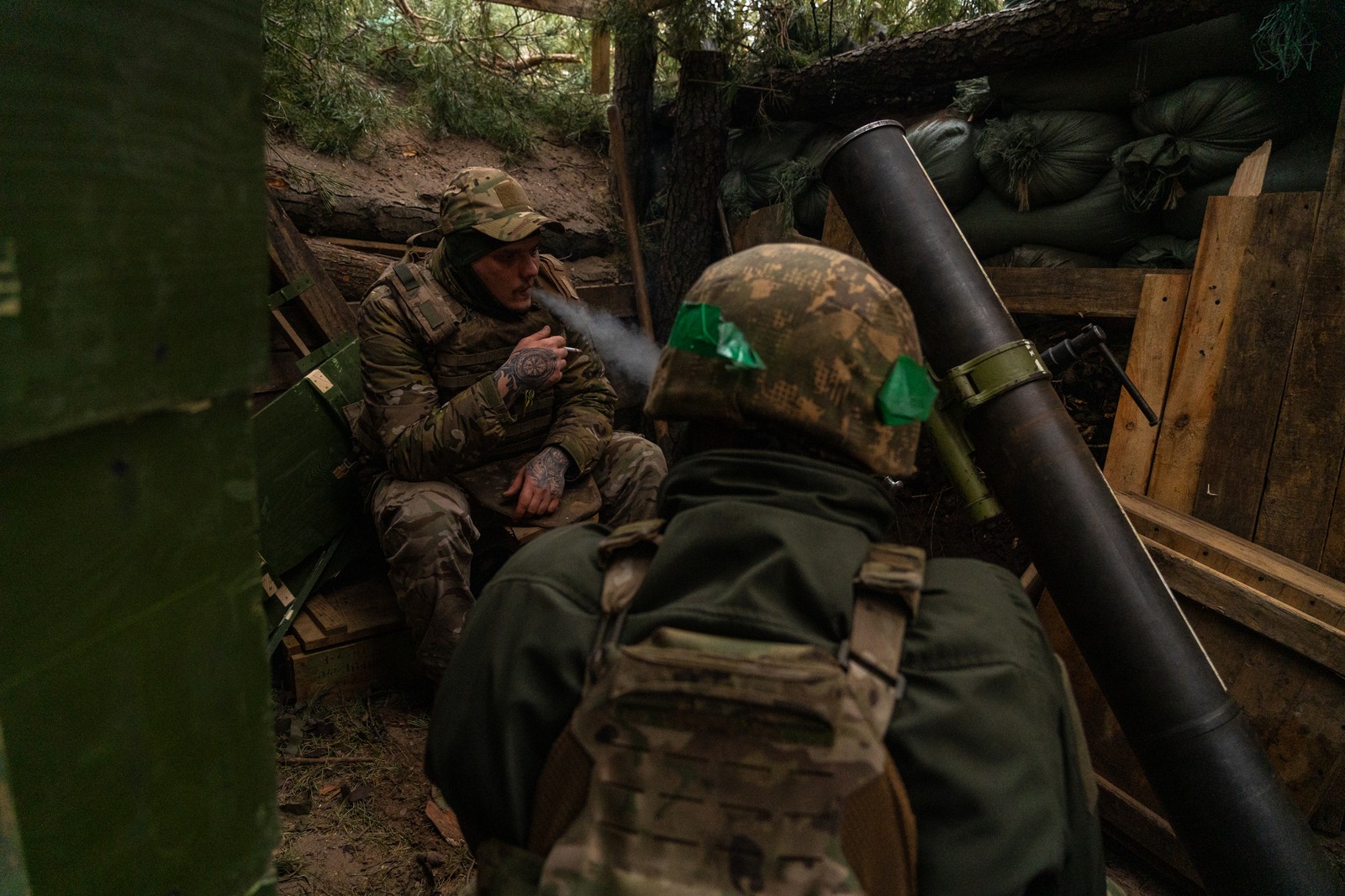 Soldados ucranianos aguardam ordens para disparar contra posições russas distantes apenas três quilômetros dali. Com a escassez de munições, os soldados passam horas e horas aguardando ordens para disparar. Foto tirada na Floresta de Kremina, Oblast de Donetsk, Ucrânia — Foto: Yan Boechat