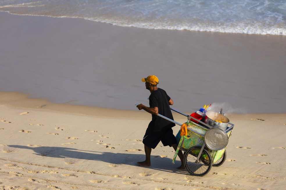 Ambulante em praia carioca: trabalhadores expostos a calor intenso e prolongado podem ter saúde afetada — Foto: Leo Martins