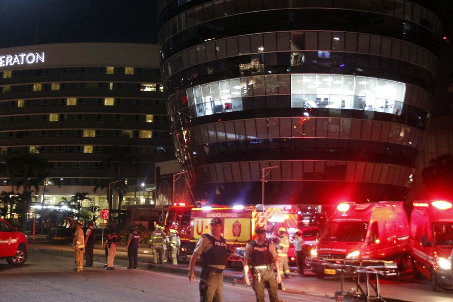 Policiais e bombeiros na cena do crime onde um carro-bomba explodiu em frente a um shopping no norte de Guayaquil, Equador