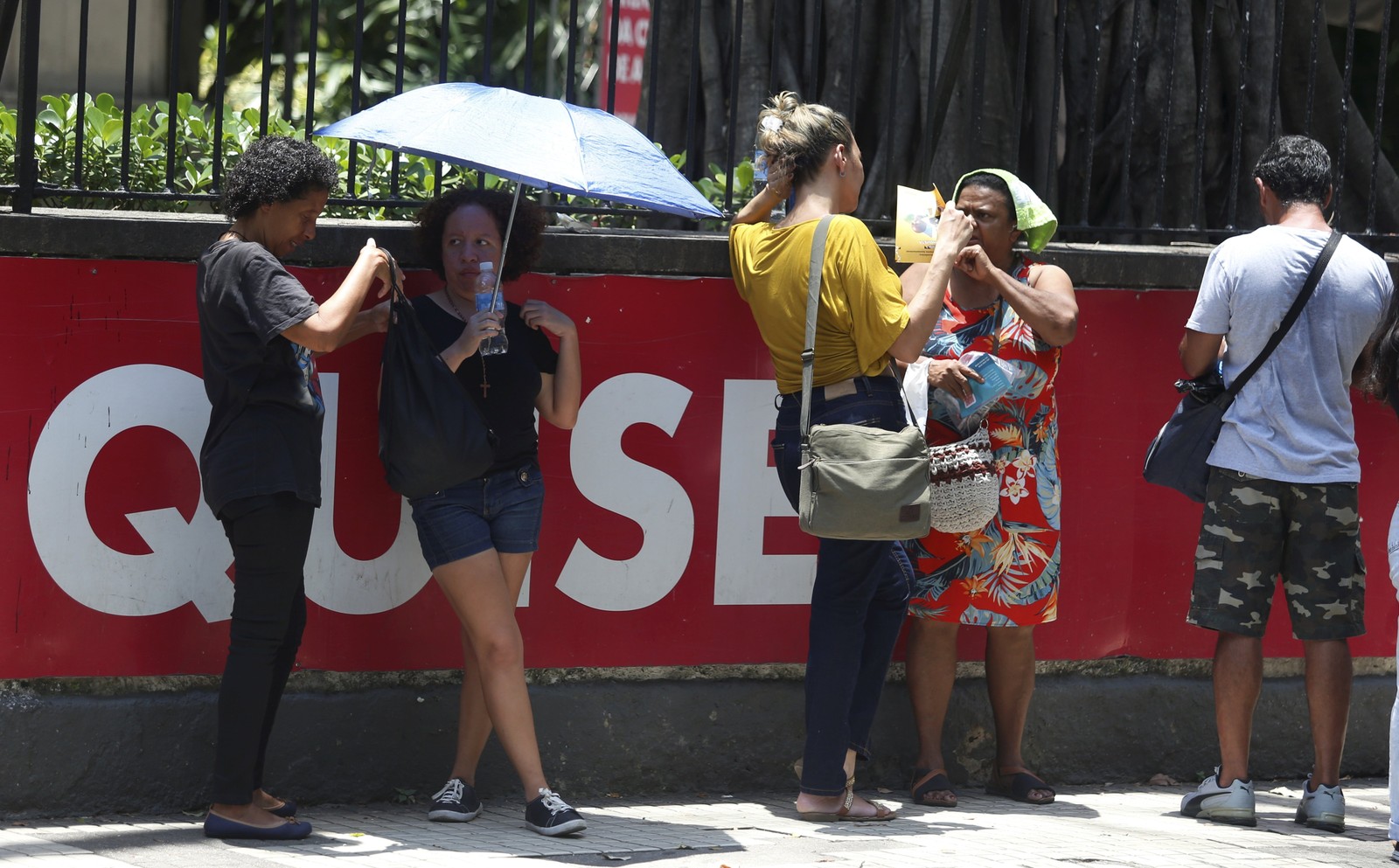 No ENEM, candidatos esperaram com guarda-chuvas para se proteger do Sol — Foto: Fabiano Rocha/Agência O Globo
