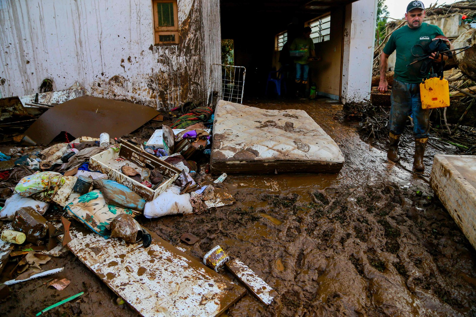 Um homem tenta recuperar seus pertences após um ciclone em Muçum, Rio Grande do Sul — Foto: SILVIO ÁVILA/AFP