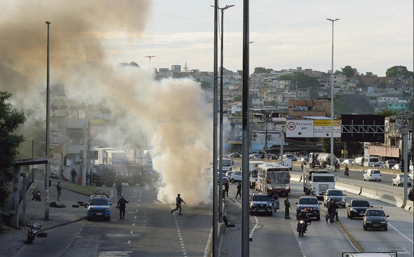 A car set on fire by drug traffickers closes the side lane of Avenida Brasil, near Cidade Alta: bandits also set up roadblocks throughout the favela to prevent the advance of police forces — Photo: Domingos Peixoto / Agência O Globo