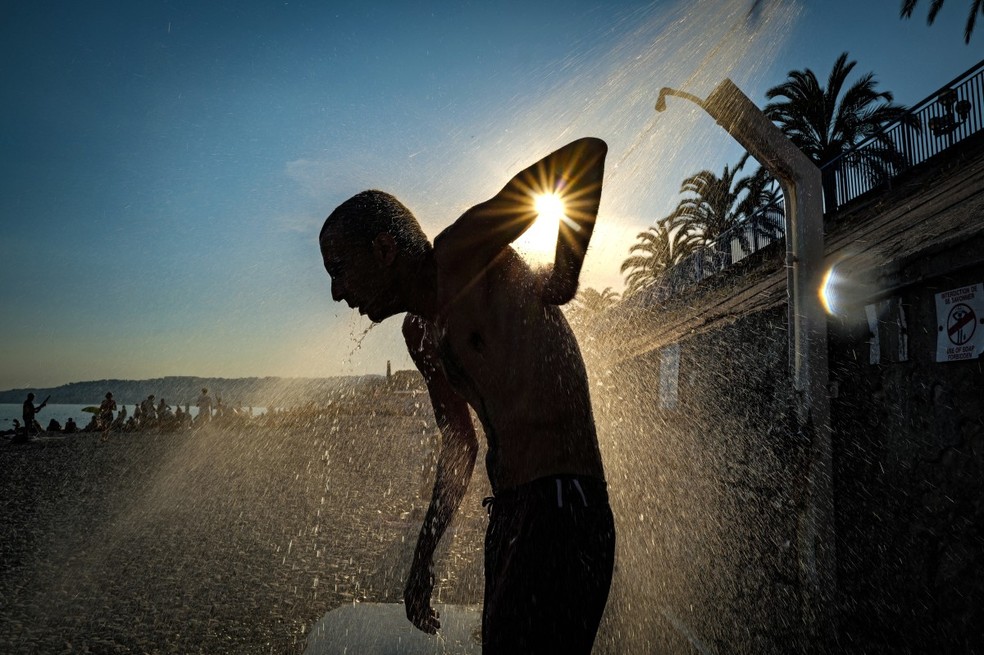 Um homem toma banho na praia ao longo da "Promenade des Anglais" na cidade de Nice, na Riviera Francesa, em 26 de junho de 2026 — Foto: VALERY HACHE / AFP