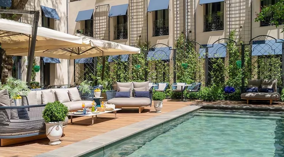 O pátio interno do CoolRooms Palacio de Atocha conta com piscina e área para refeições. — Foto: Divulgação