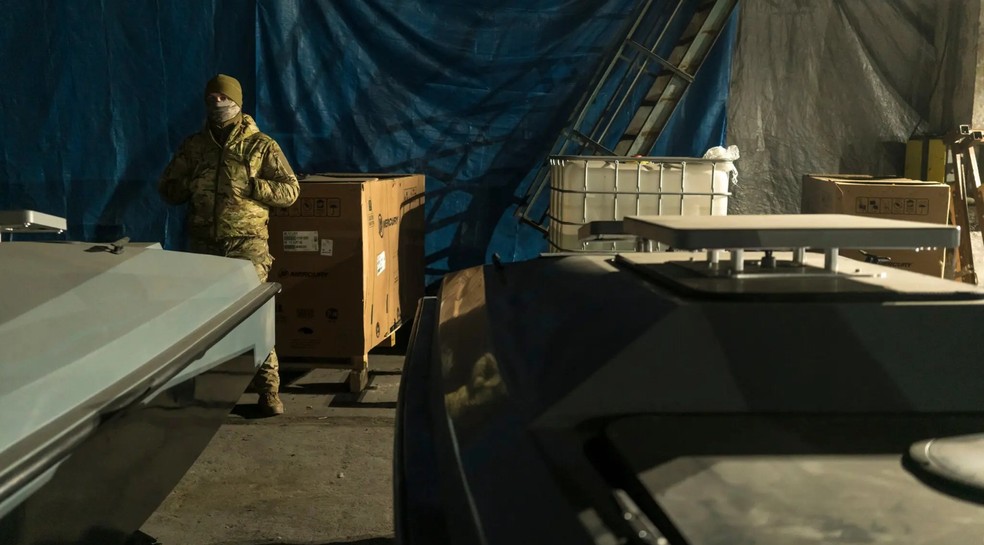 Um membro do serviço de inteligência militar da Ucrânia mostrando drones marítimos aos jornalistas — Foto: Brendan Hoffman / New York Times