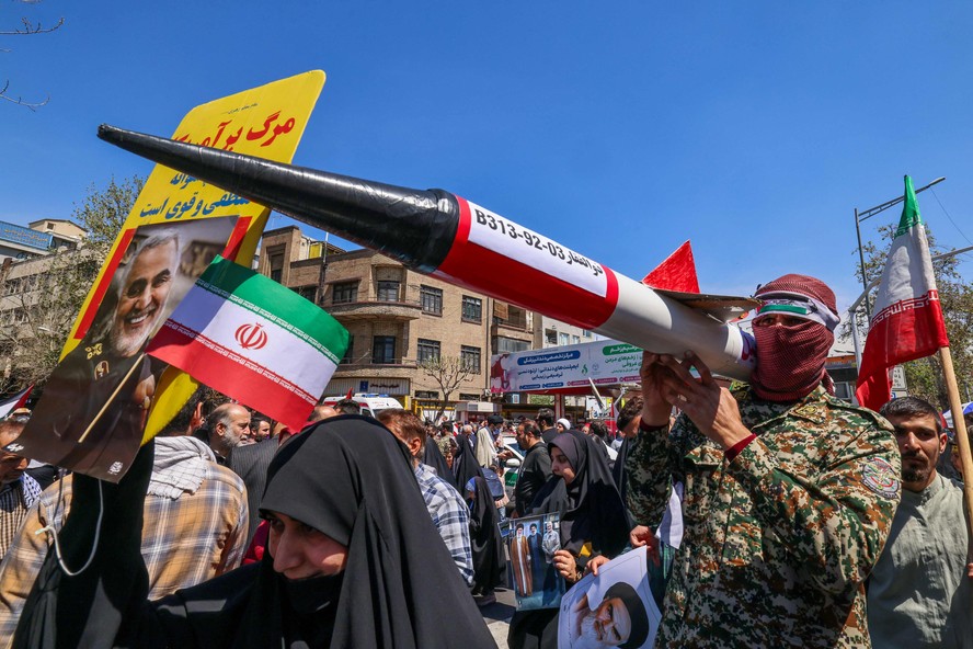 Iranianos levam maquete de foguete durante procissão em homenagem aos mortos em ataque a consulado iraniano em Damasco