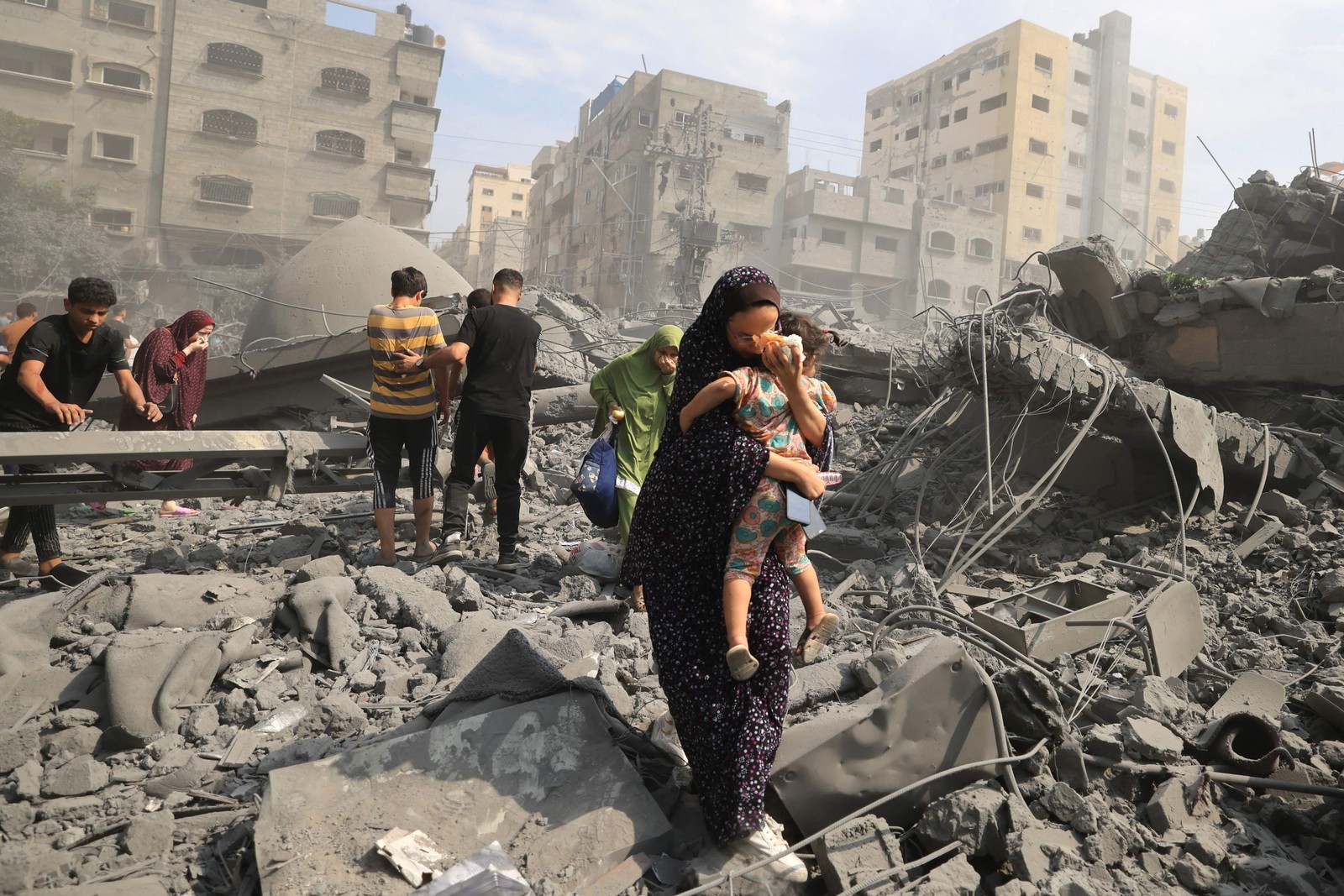 Mulher palestina carrega criana na Faixa de Gaza aps represlias de Israel aos ataques surpresa de Hamas  Foto: Mahmud Hams/AFP